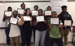 Group of students who completed Dual Enrollment Program holding up their diplomas.