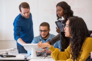 A diverse group of UBalt students working in a classroom