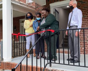 Image of Tiffany Green cutting the ribbon on her renovated home.