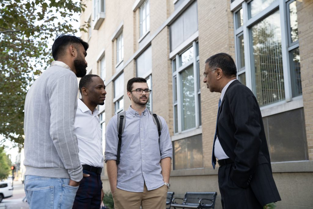 University of Baltimore students Farhan Aslam, Elisha Urayayi and Sean Curley talk with Dean of the Merrick School of Business, Raju Balakrishnan.