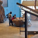 A father and his two children using the interacted activity at the Dinosaur exhibit  