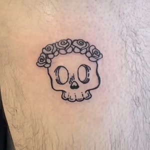 Tattoo of skull with flowers on crown