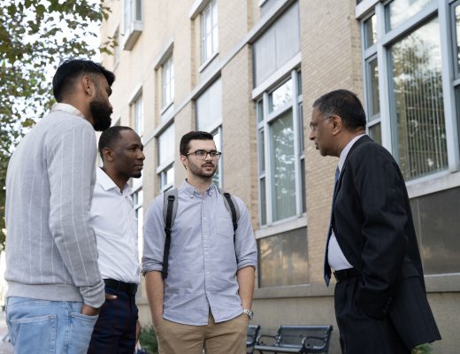 University of Baltimore students Farhan Aslam, Elisha Urayayi and Sean Curley talk with Dean of the Merrick School of Business, Raju Balakrishnan.