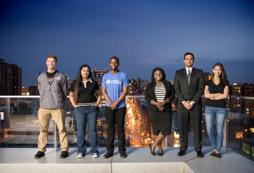 Six University of Baltimore students atop the John and Frances Angelos Law Center with Noah Johnston (far left) and Sabrina Flores (far right).